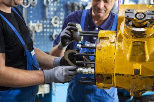 Zwei Servicetechniker bei der Reparatur eines Fahrzeugbauteils