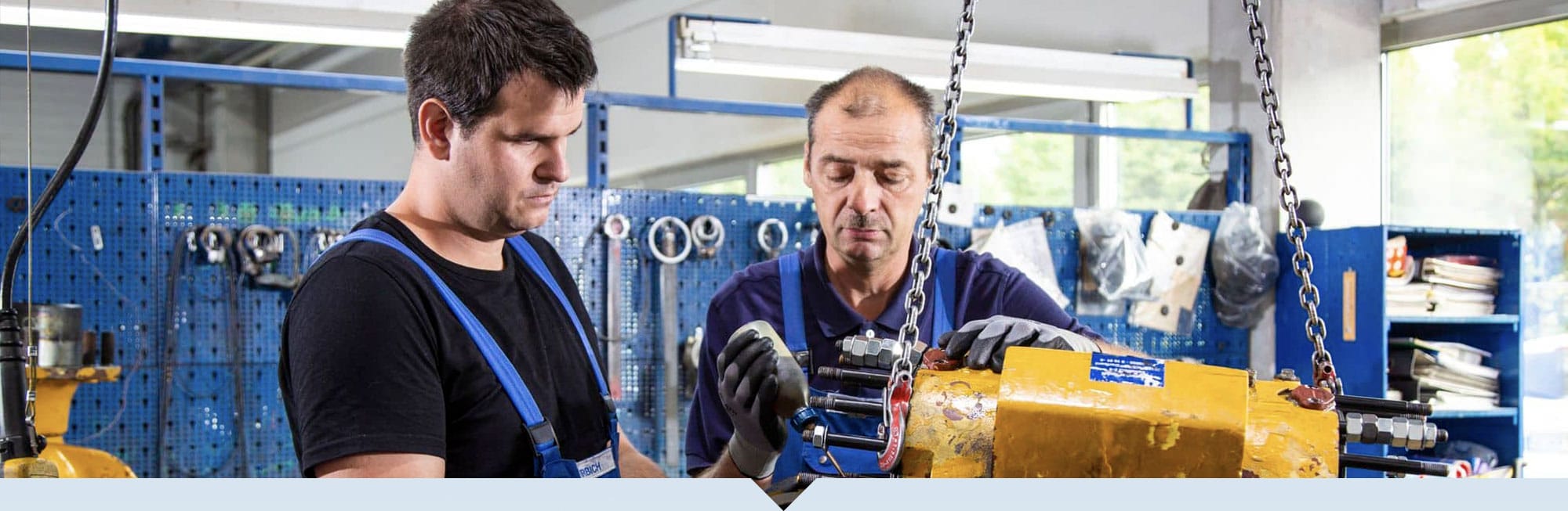 2 Monteure arbeiten an der Krananlage.