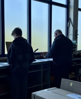 Schüler und Mitarbeiter im Lagerbereich während des Zukunftstags bei Fikentscher